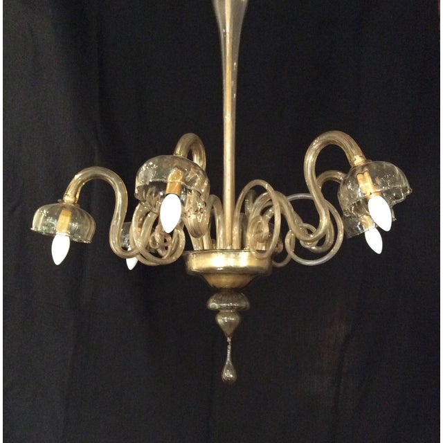 The chandelier features the manufacturer's acid signature on the glass cup. This piece has an attribution mark, I am sure...