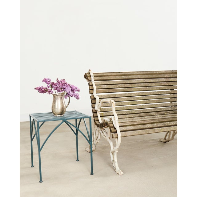 Grand country English Victorian period garden bench featuring cast iron faux bois legs. The legs are conjoined by wood...