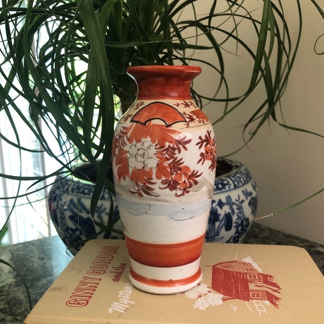 Japanese Kutani hand painted porcelain vase. Painted in earth tone reds, very pale sky blue and touches of ink black....