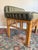 Vintage bamboo and rattan stool featuring a warm honey-toned frame with wrapped joints and decorative spindle detailing....