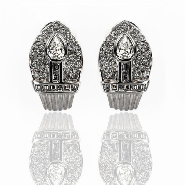 14k White gold earrings with 3 pearshape diamonds weighing approximately 0.85 carats and 16 bagutte cut and 64 round...