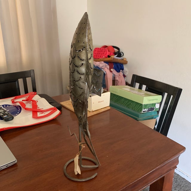 Add a touch of coastal charm to your home with this unique handcrafted metal fish sculpture. Made from sturdy, textured...