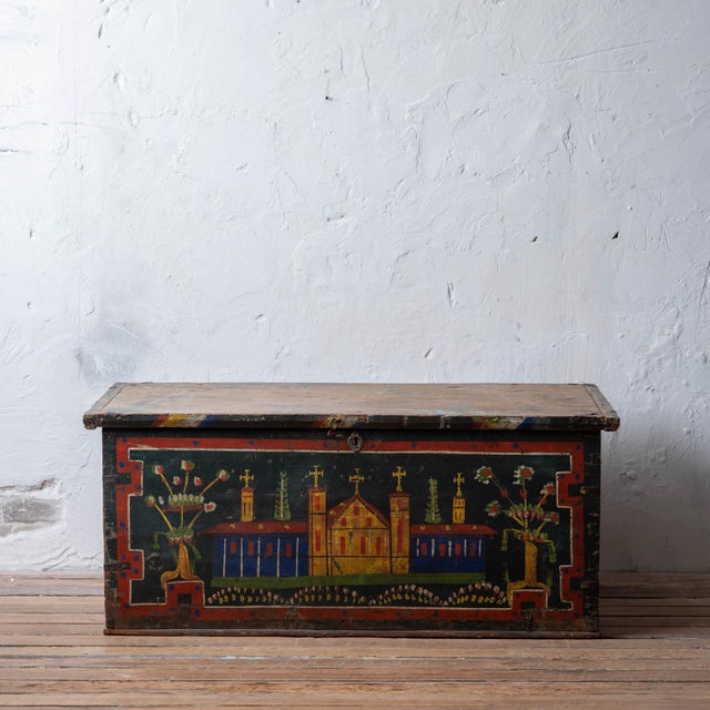 Painted pine blanket chest featuring a hand-painted church facade framed by floral urns and geometric borders, circa 1900....
