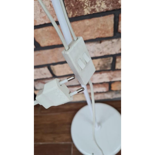 White floor lamp with two adjustable reflectors, manufactured in the 1960s or 1970s. The lamp has a minimalist design and...