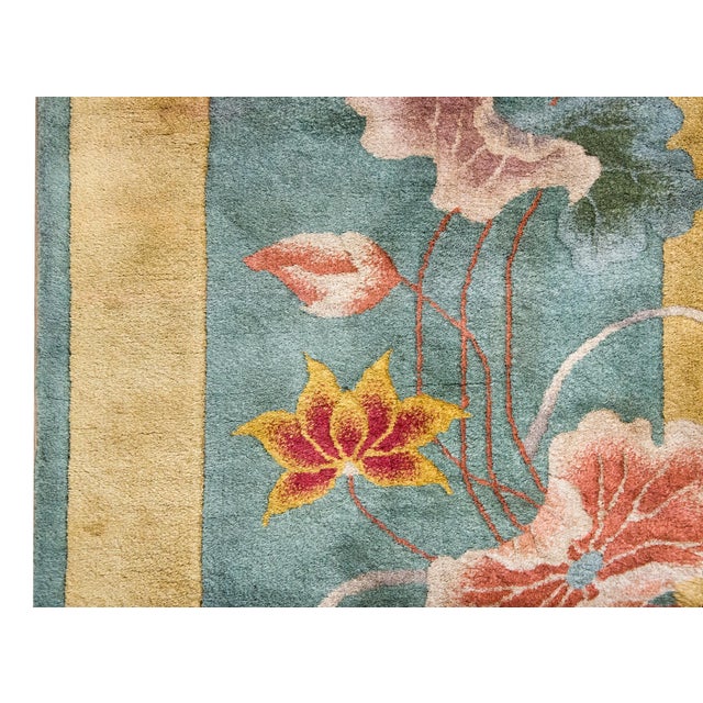 A beautiful early 20th century Chinese Art Deco rug with a pale mint green field surrounded by a wide yellow border, and...
