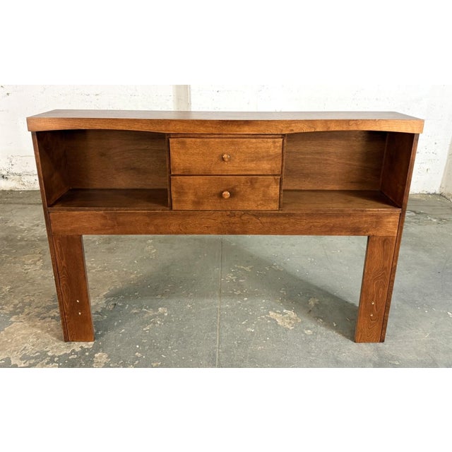 This full size bookcase headboard features a warm wood finish with two open storage cubbies and a pair of centered drawers...