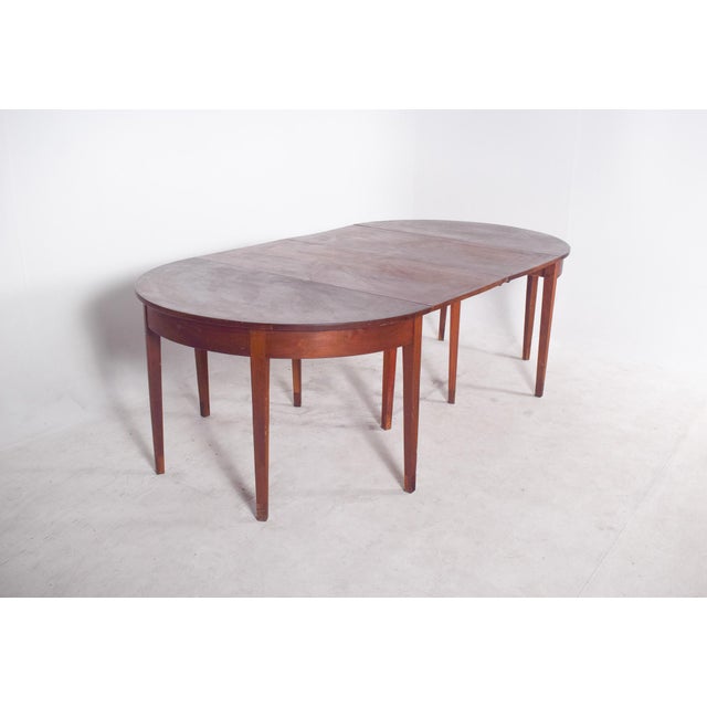 Rectangular extendable dining table. The top has straight edges with a stepped profile, showing a geometric design...