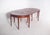 Rectangular extendable dining table. The top has straight edges with a stepped profile, showing a geometric design...