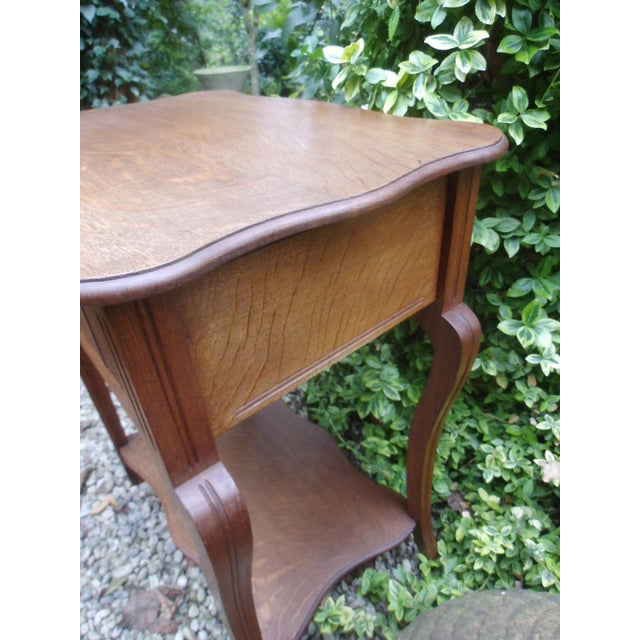 An antique oak dressing table with a fold-up top and a drawer with many compartments. The attractive look, with its...