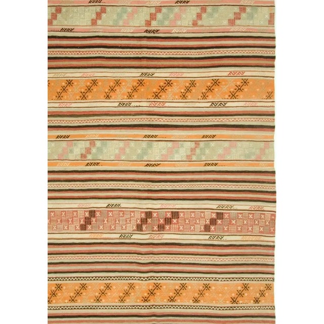 This Turkish kilim, handwoven in the 1940s, showcases a captivating blend of stripes and geometric patterns.