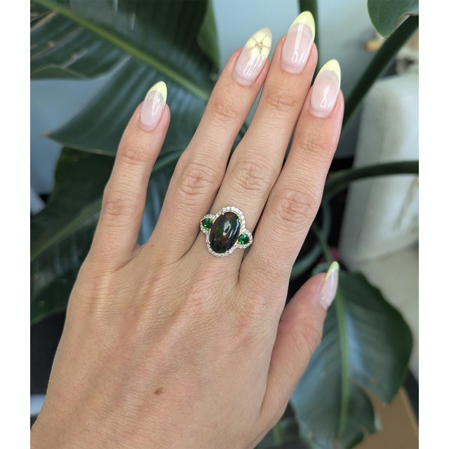 This striking Black opal ring showcases a rare 3.8ct oval Ethiopian black opal with vibrant play-of-color, set in solid...
