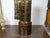 An English black and gold corner cabinet from the 19th century, with paneled glass doors, three middle drawers and...