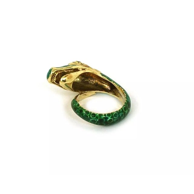 This is an eye catching coiled band ring, it features a snake head ring with green scale like pattern enamel and emerald...