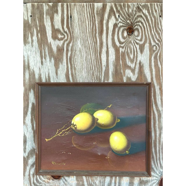 An exceptional vintage original oil painting depicting a timeless still life of sun-ripened lemons resting gracefully upon...