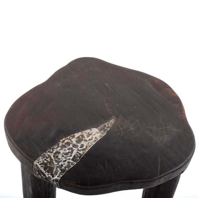 This antique African ebony wood and metal stool is a unique piece that displays the beauty and craftsmanship of African...