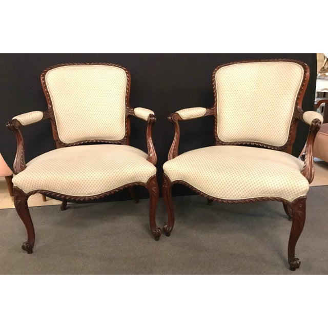 A fine pair of Louis XV style walnut fauteuils or Bergères in a Scalamandre Fabric. A simply understated pair of carved...
