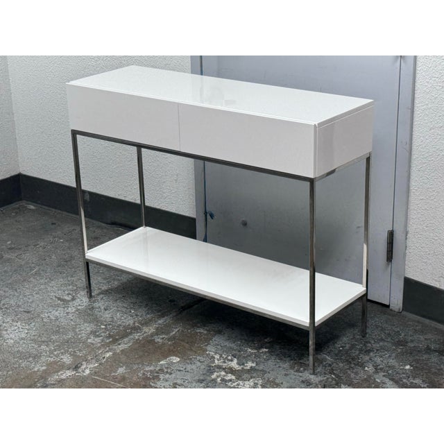 Design Plus Gallery presents a Console Table from West Elm. The console has a sleek white lacquered finish paired with a...