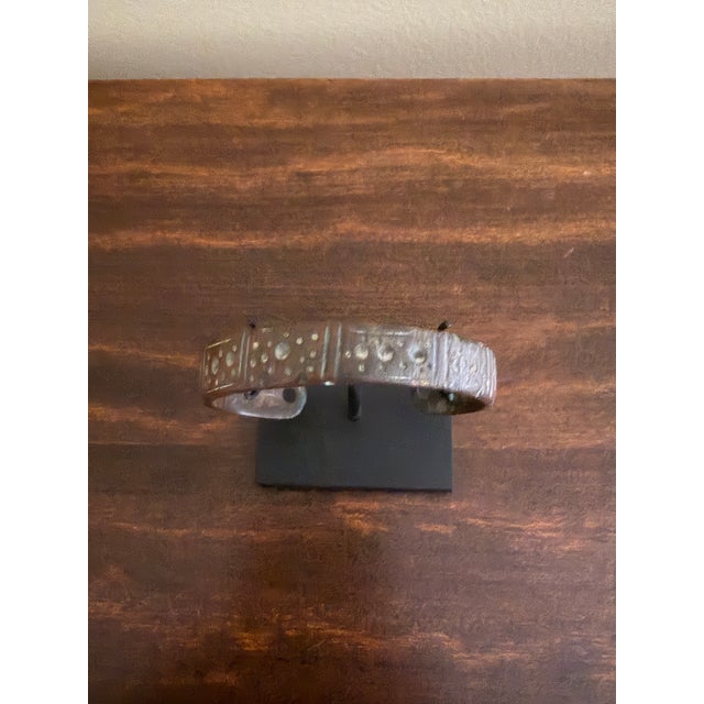 A striking ancient Roman bronze cuff bracelet dating to the Imperial Roman period, circa 100–300 AD, now presented on a...