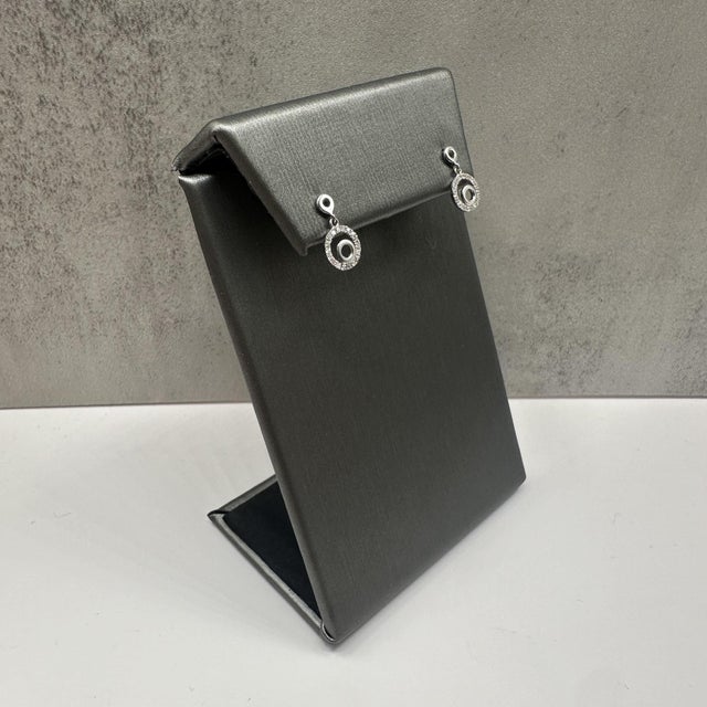 These elegant round diamond circle drop dangle earrings in 14kt white gold feature 0.14 carats total weight of natural HI...