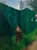 Fortitude by Jodi Gerbi | Oil on panel Oil painting of a fire hydrant beside a green construction fence. For Sale