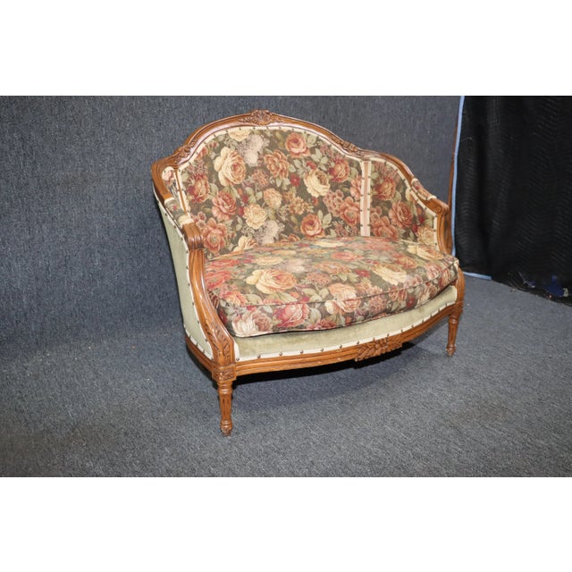 Vintage Louis XV style settee with walnut frame and carved accents with cabriole legs. Newer floral upholstery with...