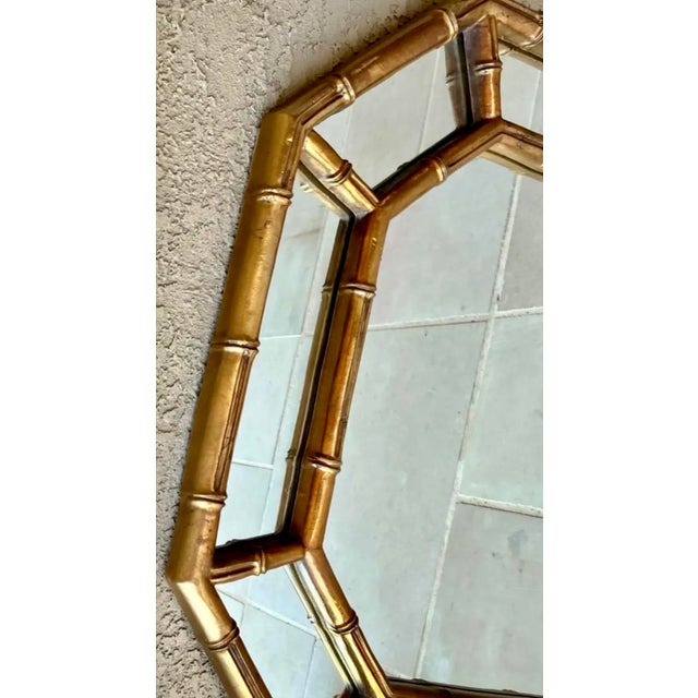 Offering a vintage Hollywood Regency style faux bamboo mirror for your consideration. . The antique gold finish has black...