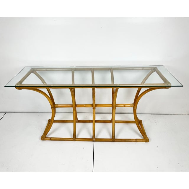 Vintage rattan console table with glass top. Arched cage style. Curved lines with cane wrapped joints. Glass top is 3/8"...