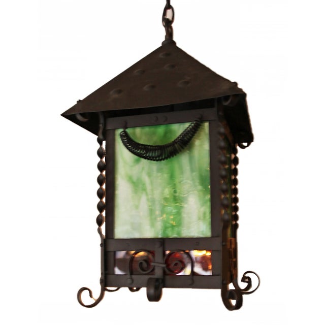 Vintage iron hanging lantern with green and red stained glass.