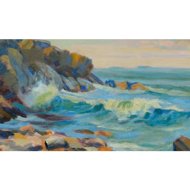 Charming 1930's impressionistic seascape of blue waves crashing on a rocky shore with distant sail boats on the horizon by...