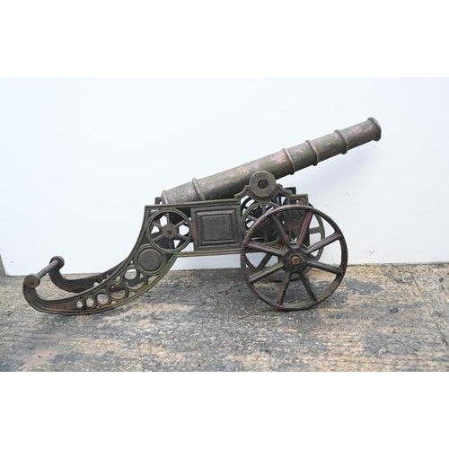 Antique style English decorative cannon model on wheeled carriage. Impressive model cannon with elongated barrel mounted...