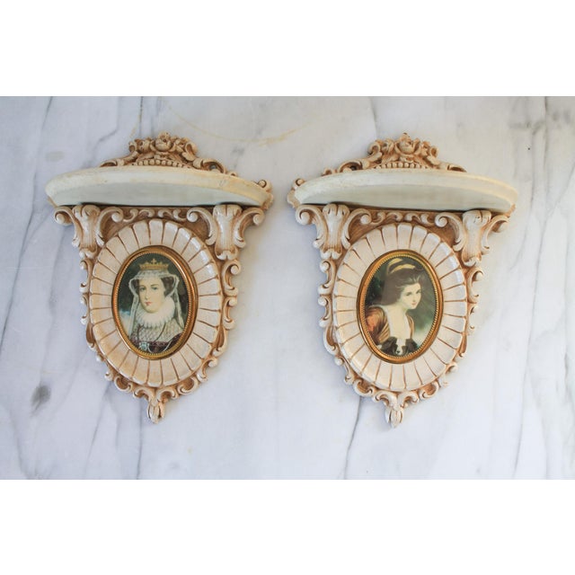 Pair of petite ornate wood wall shelves with cameo portraits. No makers mark. Some age wear to wood. Pictured.