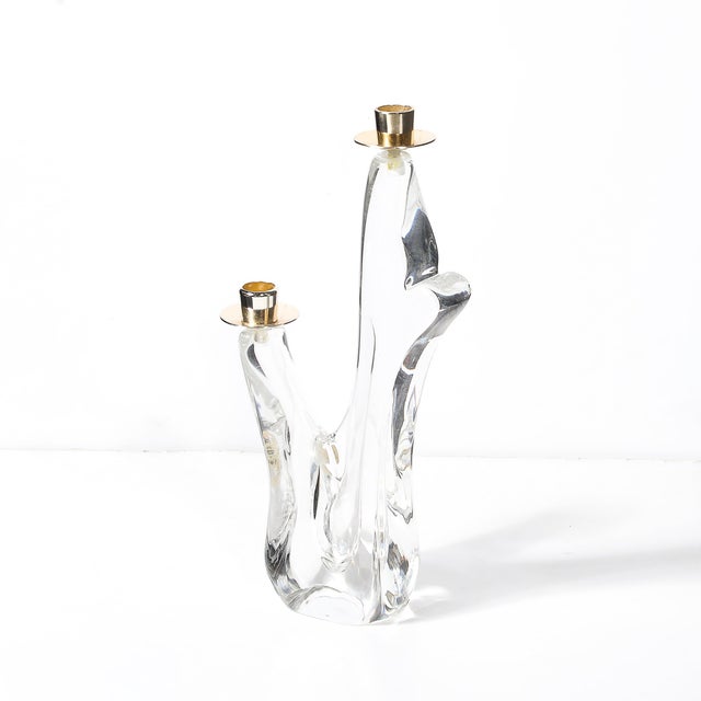 This Mid-Century amorphic crystal and brass candle holder, signed Schneider, France, circa 1950, is an elegant embodiment...