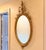 Adams Style Oval Wall Mirror Beveled glass supported by a gilt frame. 23” x 49”