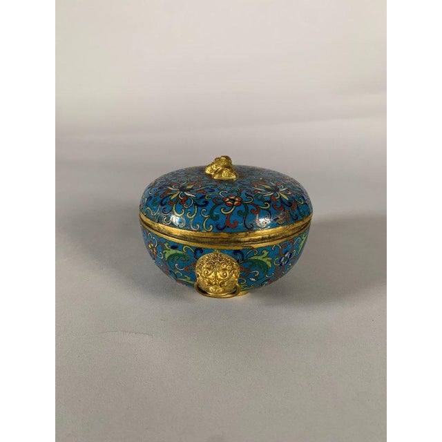 A Chinese cloisonné bronze box, Jiaqing period, 19th century , cloisonné on a blue ground with floral motifs. The handle...