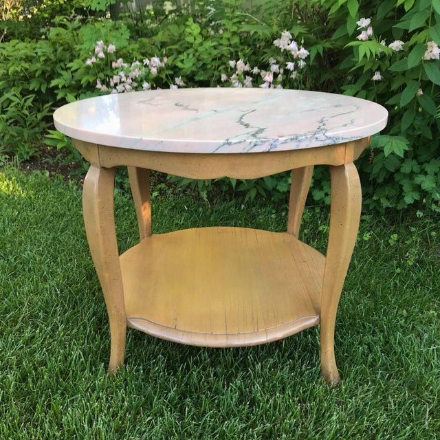 This pretty marble-topped side table features veins of light pink, dark gray and a lovely bit of blue. The heavy,...