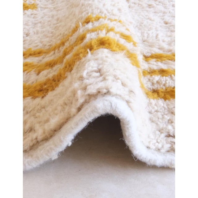 This Yellow Moroccan Modern Area Rug, sized 11.4 by 8 feet, is made from soft sheep wool and features a striking geometric...