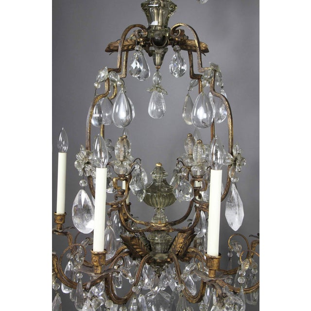 Typical form with four small arms with drops over a cage with drops overall and central urn over eight branches with...