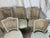 Elegant set of five French Louis XVI style dining chairs featuring hand-caned backs, carved floral details, and fluted...