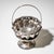 Neoclassical silver bowl with handle, set on a circular foot and decorated with stylized leaf ornaments along the body. A...