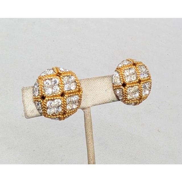 1960s round goldtone "checkered" earrings with groups of four round clear rhinestones with rhodium plated surround clip...