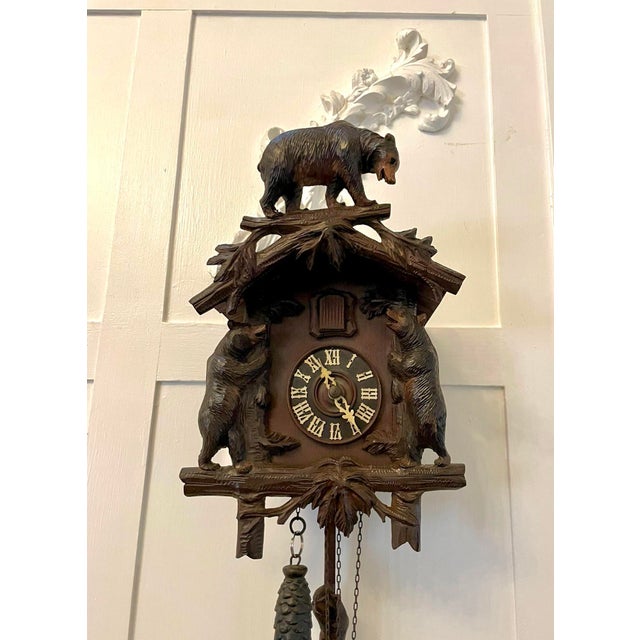 A striking and highly decorative antique Black Forest cuckoo clock beautifully hand carved with an expressive bear...