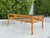 Striking vintage coffee table featuring an elaborate bamboo-style rattan frame with sculptural curved supports, wrapped...