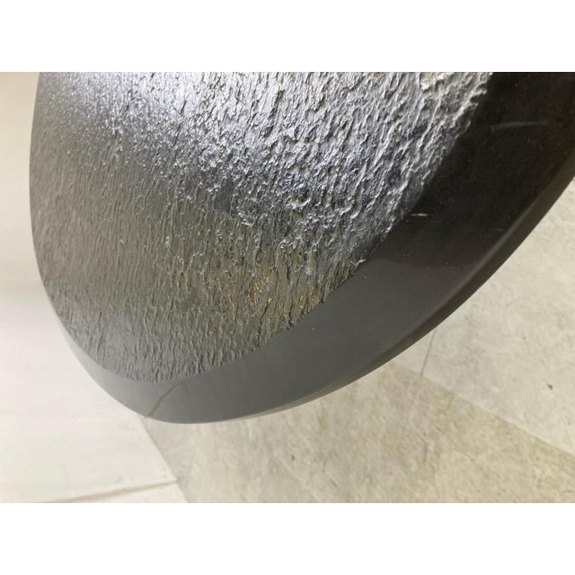 Vintage unusual coffee table with a black stoneware table top with a brutalist relief and a sculpted black lacquered...