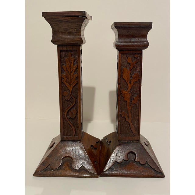 A near pair of Mission carved oak candlesticks with metal insert candle cups. Different carved arts and crafts and folk...