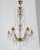 An early 20th century French Louis XV style six-light chandelier with an assortment of crystal prisms and pendalogues,...