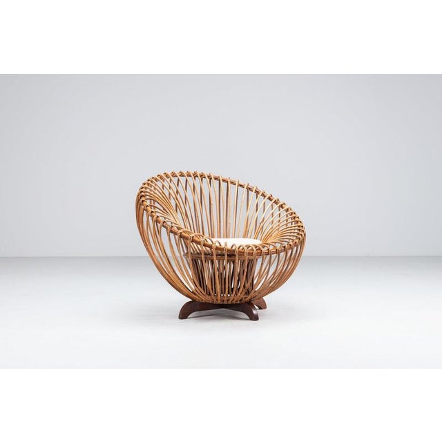 A beautiful and sculptural lounge chair in the style of Franco Albini, Italy 1950s. Crafted from natural rattan and teak,...