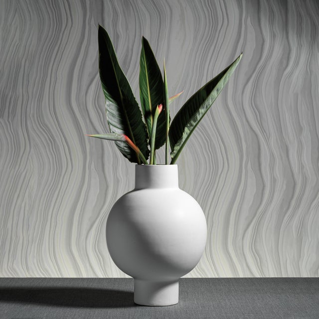 A modern, contemporary ceramic vase with a slender neck and robust center, suitable for flowers, or being displayed empty....