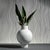 A modern, contemporary ceramic vase with a slender neck and robust center, suitable for flowers, or being displayed empty....