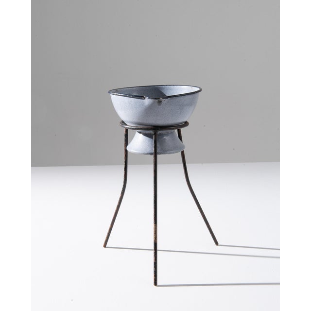 A 20th century enameled bowl on stand from Central Europe, this small antique bowl is elevated on metal legs. Exhibiting a...