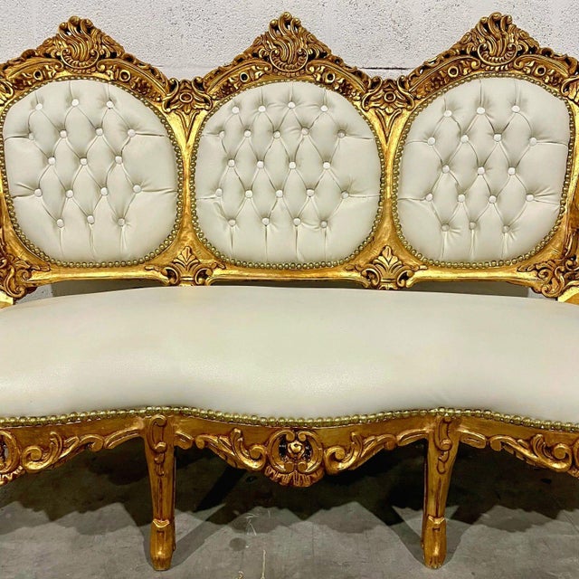 This elegant French Rococo sofa features pristine white leather upholstery paired with a fully refinished gold leaf frame,...